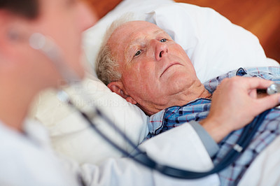 Doctor examining an elderly man\'s heart beat
