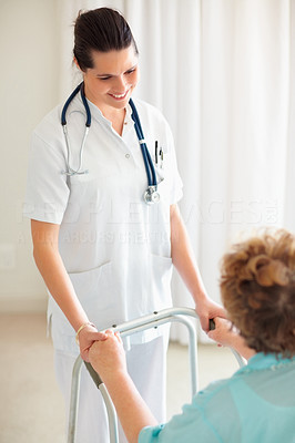Nurse helping a patient to stand on a walker