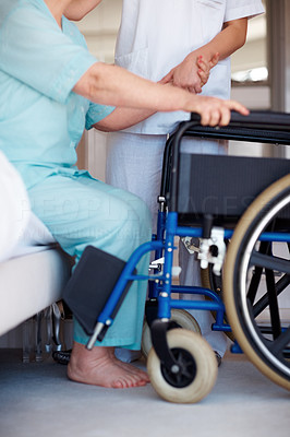 Low section Nurse helping a senior woman onto a wheelchair