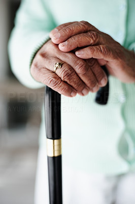 Closeup focus of a senior woman\'s hand on a walking stick