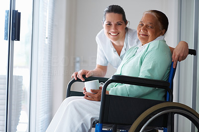 Elderly woman on a wheel chair with a nurse by her