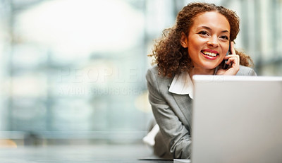 Cute young business woman using a laptop on the floor