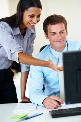 Business woman helping a colleague on a computer