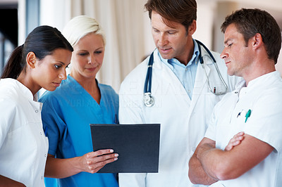 Medical practitioners discussing on a report of a patient