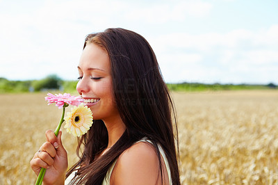 An attractive female holding flowers at countryside