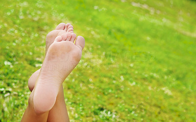 A woman\'s bare feet on a green grass background