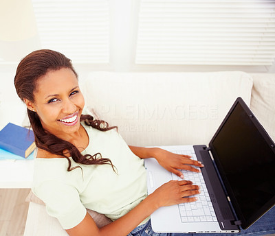 Happy African American woman using a laptop at home