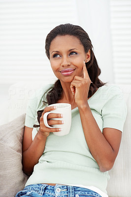 Cute young female in thought while a cup of tea at home
