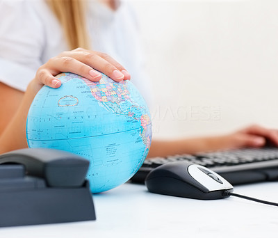 Business woman\'s hand placed on a world globe