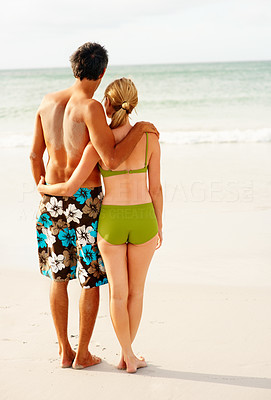 Beach vacation - Rear view of a couple standing on the sea shore