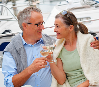 Happy senior couple having champagne while on sea voyage