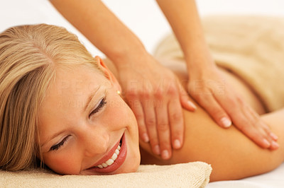 Happy young woman enjoying a back massage at the spa