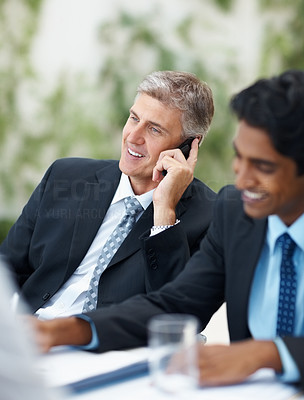 Smart business man speaking on the phone while at a meeting