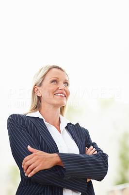 An attractive business woman dreaming with her hands folded