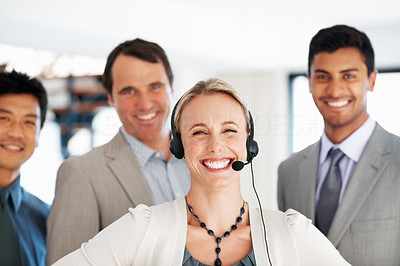Female customer care representative smiling with office colleagues