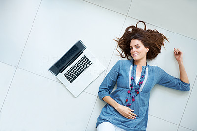 Charming young female lying on the floor with laptop