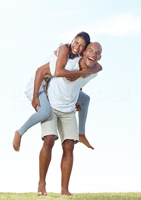 Laughing young man giving a piggyback ride to his girlfriend