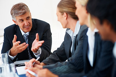 Business man speaking to his colleagues at a boardroom meeting