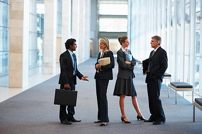 Image of business associates standing in discussion at the hallway