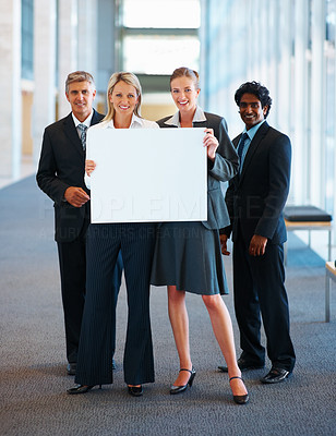 Team of business colleagues holding a blank billboard