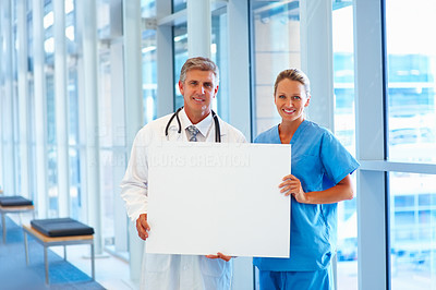 Professional doctors holding a blank board