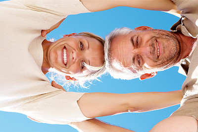 Upward view of an old couple with blue sky as the background