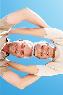 Upward view of a senior couple with with blue sky in the background