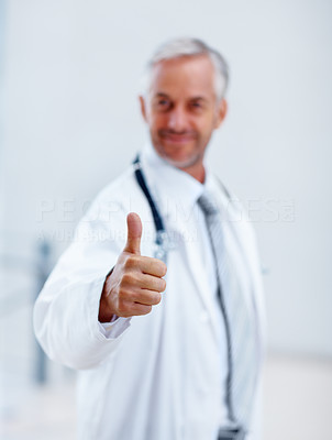 Mature doctor showing a success sign