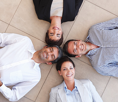 Business people lying in a circle on the floor
