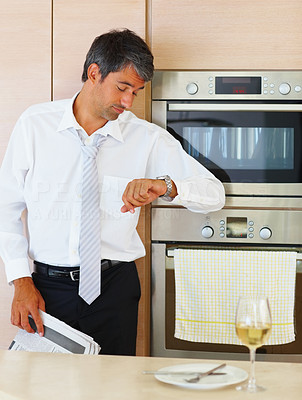Running late: Business man in front of a champagne glass by the oven