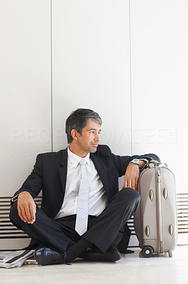 A business man sitting on the floor, looking away
