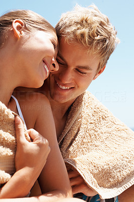 A cute couple wrapped in a towel sitting together