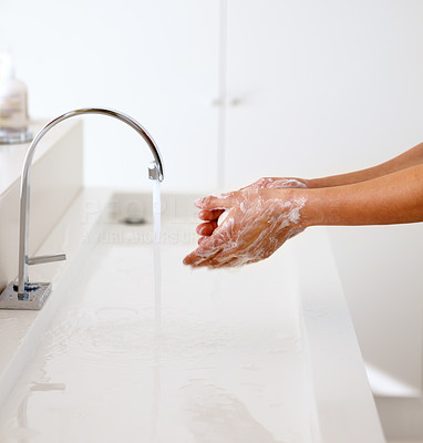 Person washing hands under a tap
