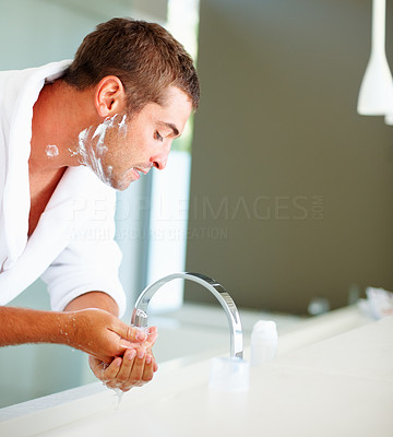 A young man washing face in a bathroom