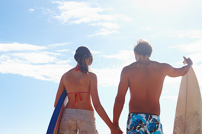 Rear view of a young couple with surf boards