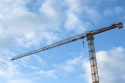 A photo of a huge red crane with blue sky as background