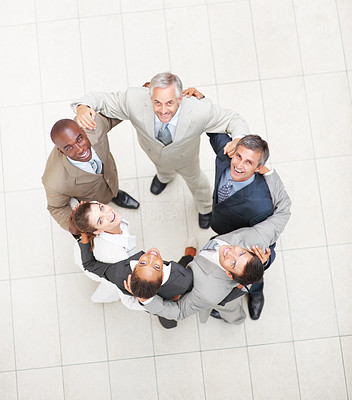 Successful positive business people forming a huddle and looking upwards