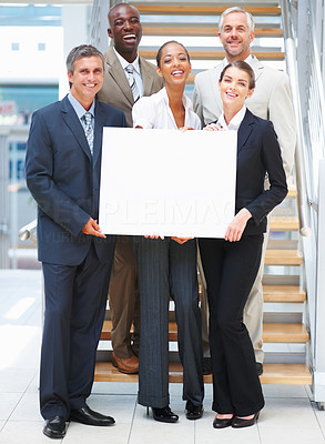 Business woman holding a blank board on the stairs