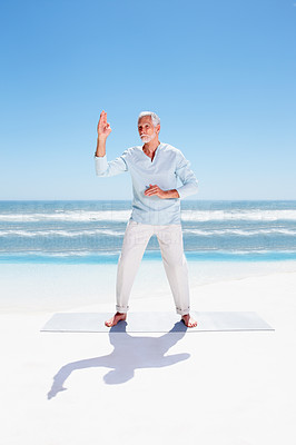 Fit old man practicing martial arts on the sea shore