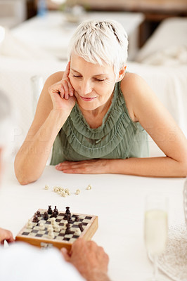 Happy senior woman chess player during a game