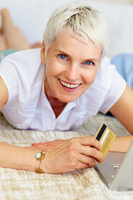 Cute grandmother using credit card to shop from the net