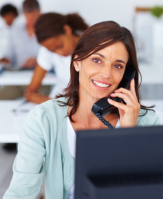 Closeup of a happy business woman speaking on the phone at work