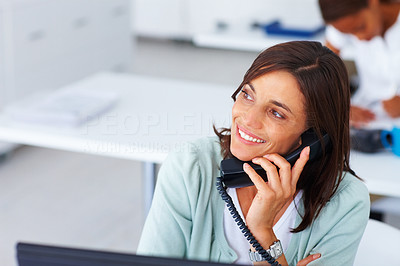 Happy business woman speaking on the phone at work