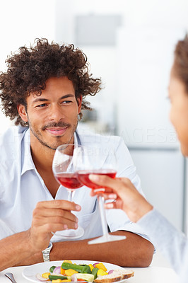 Happy young couple on a date having red wine and a meal together