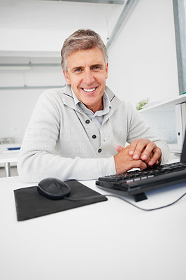 Handsome mature business man sitting in front of a computer