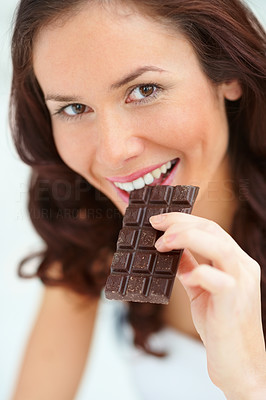 Closeup portrait beautiful young female eating a chocolate bar