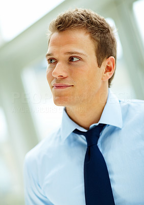 Handsome young business man looking away and day dreaming