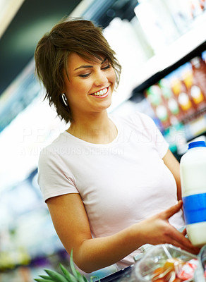 Happy young woman purchasing grocery at the store