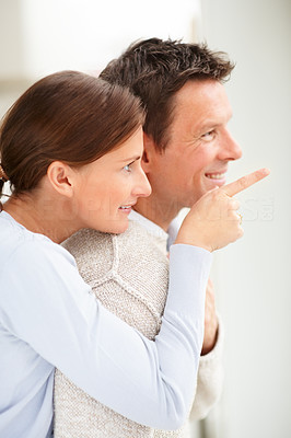Young woman pointing away and showing something to her husband