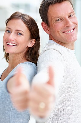 Happy young confident couple showing a thumbs up